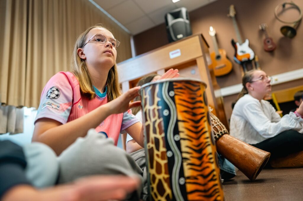 Atelier musique du midi : des collégiens jouent des percussions dans la salle aux guitares
