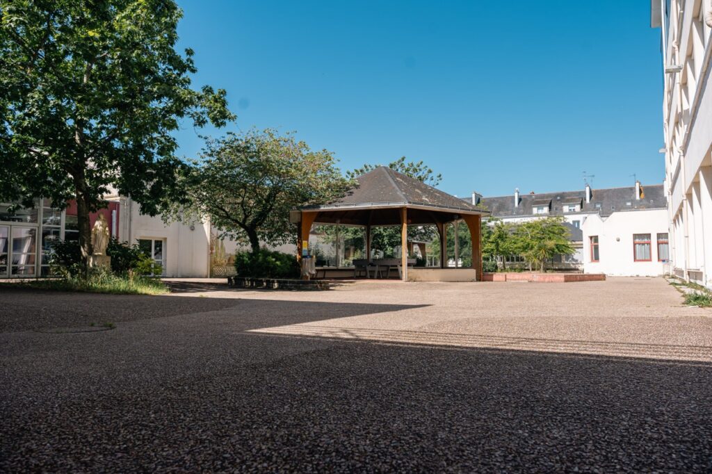 La cour arborée et le kiosque d'un établissement de l'ensemble scolaire