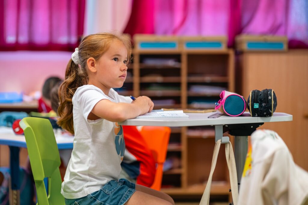 Une élève de primaire travaille à sa table en classe